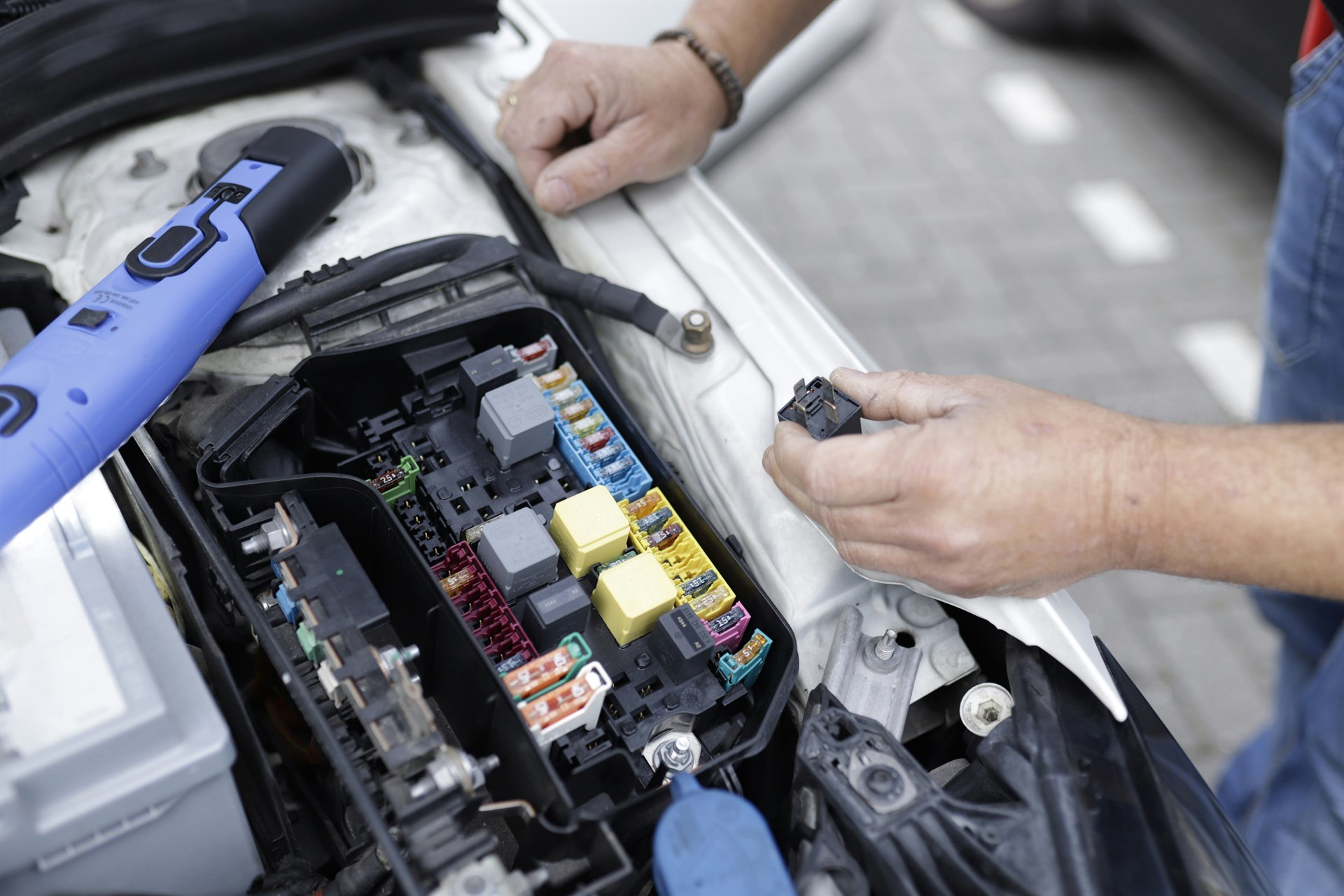 Técnico realizando manutenção no sistema elétrico de um automóvel